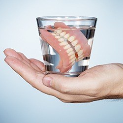 Full set of dentures in glass of water