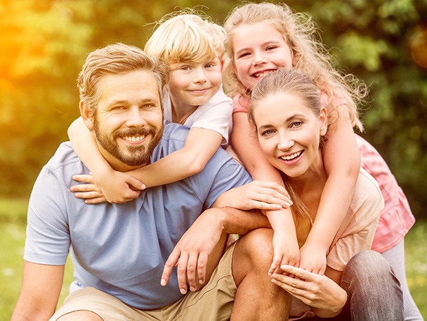 Smiling family of four outdoors