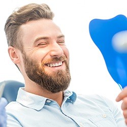 Man looking at his smile in the mirror