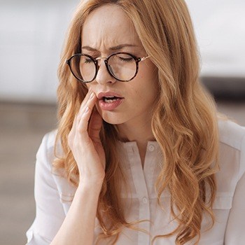 Woman holding her jaw in pain