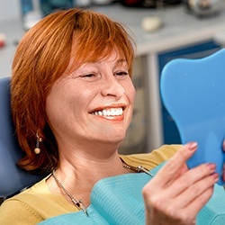 Woman looking at her smile in the mirror