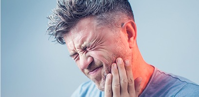 Man in pain holding cheek