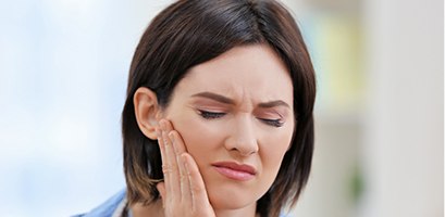 Woman in pain holding cheek