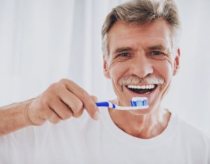 older man brushing his teeth