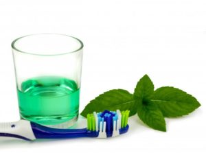 Toothbrush, mouthwash, and mint leaves