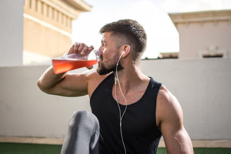 Man drinking a sports drink while exercising